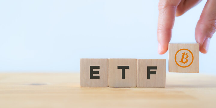 Exchange Traded Fund (ETF) and bitcoin cryptocurrency concept.  Entering the digital money fund concept. Investor holds the wooden cube with bitcoin icon standing with "ETF" text. White background.