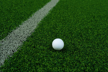 Golf ball close up on green grass on blurred beautiful landscape of golf background.Concept international sport that rely on precision skills for health relaxation..