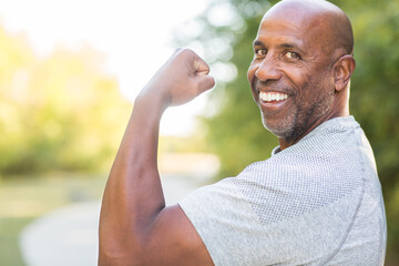 Mature African American flexing his bicep muscle.