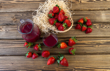 Fototapeta na wymiar Strawberry in basket and on table on wooden background, strawberry juice in jug