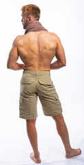 Fototapeta na wymiar a muscular man in shorts with a towel around his neck stands with his back to us and looks away. isolated, white background