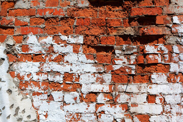 Damaged brick wall . Red and white bricks surface