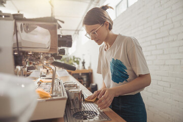 Charming female barista cleaning counter in coffee shop
