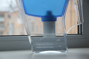 Water filter jug with a glass of clean water