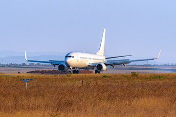 Fototapeta na wymiar Passenger plane taking off from runway at airport on sunny day.