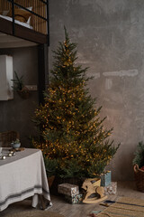 Modern home interior design concept. Comfortable cozy living room decorated with Christmas tree with gifts, table, grey walls, toys. Christmas, New Year celebration decorations.