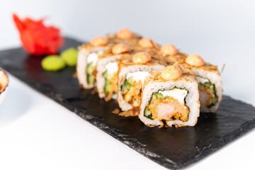 Tempura shrimp roll
on a blackboard on a white background close up