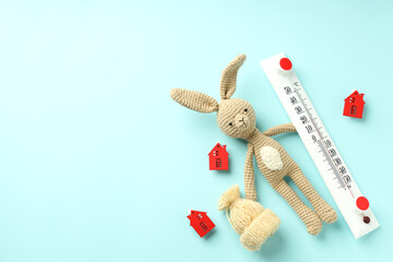 Concept of heating season with toy rabbit on blue background