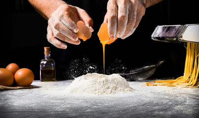 Hombre haciendo pasta echando huevo en volcán de harina y fondo con maquina de hacer pasta y otros.