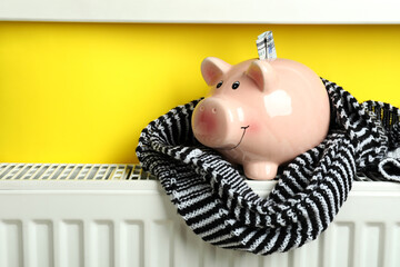Concept of heating season with piggy bank on radiator