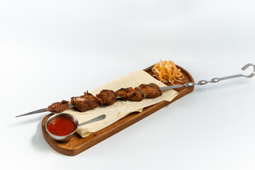 lamb kebab on lavash on a wooden board
on a white background