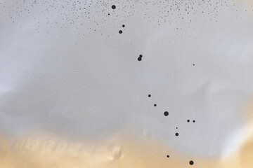 black and silver spray paint on gold colored paper