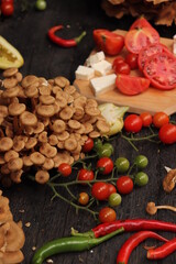 Food photography, plating of cherry tomatoes, mushrooms, peppers and sliced ​​cheese, placed on rustic wooden table