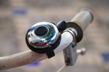 Detail of bicycle bell in shiny steel colour. Healthy transport and sports concept.