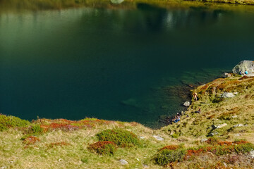 hikers bathe in a clear green mountain lake after the tour