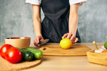 Cook woman on the kitchen cutting vegetables salad diet