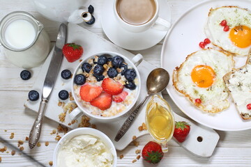 Muesli with strawberries, blueberries and milk on a white plate