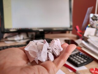 Rubbish on the desktop, crumpled paper in hand.