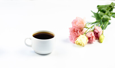 A bouquet of delicate pink flowers on the table. A cup of coffee. Breakfast. Spring. On white background.