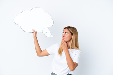 Blonde Uruguayan girl isolated on white background holding a thinking speech bubble