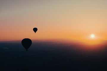 hot air balloon silhouette with sun rising over the mountains