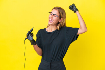 Tattoo artist Uruguayan woman isolated on yellow background celebrating a victory