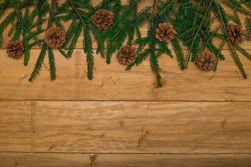 Naklejka premium Christmas background - fir branches and cones and on dark wooden boards.