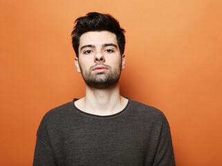Fototapeta premium young brunette handsome man posing over orabge background