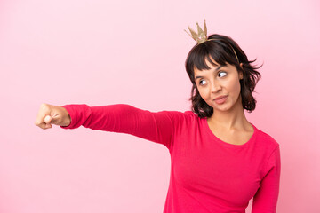Young mixed race princess with crown isolated on pink background giving a thumbs up gesture