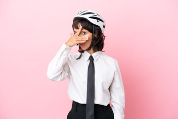 Young girl person with a bike helmet isolated on pink background covering eyes by hands and smiling