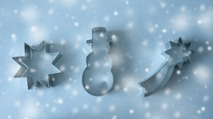 Cookie cutter on blue snowy background.