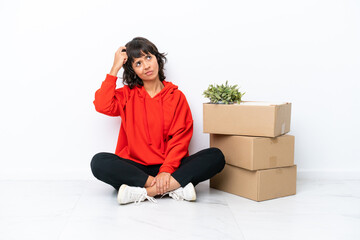 Young girl moving in new home among boxes isolated on white background having doubts and with confuse face expression