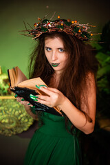 Witch with disheveled hair and long nails with a wreath of dry branches on her head, dressed in a...