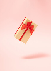 modern abstract christmas gift box in the air  against pastel pink background. futurisam. minimalism. modern creative decoration idea.