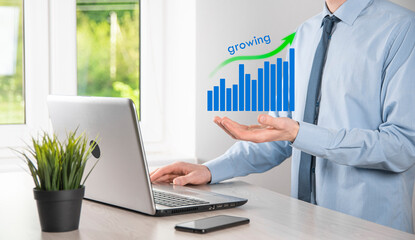 Business man holding holographic graphs and stock market statistics gain profits. Concept of growth planning and business strategy. Display of good economy form digital screen.