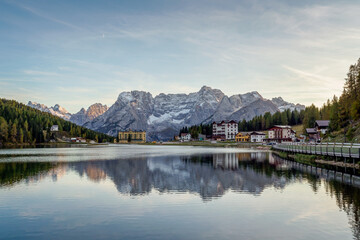Fototapeta premium Sunset over Misurina Lake with sky reflection in calm water. View on the majestic Dolomites Alp Mountains, National Park Tre Cime di Lavaredo, Dolomiti Alps, South Tyrol, Italy