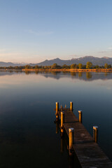 Sunrise over the Chiemsee with an old footbridge in the water