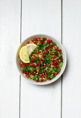 Tabbouleh salad with bulgur, mint, parsley, tomatoes and pomegranate. Healthy eating. Vegetarian...
