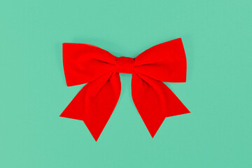 Red Christmas satin ribbon on green background