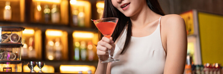Nightlife concept a sexy young woman with long hair holding the pink champaign sitting enjoying the...