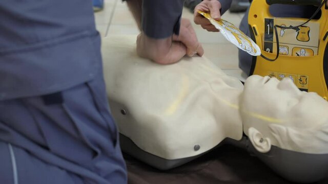 First aid cardiopulmonary resuscitation training demonstration, closeup, handheld