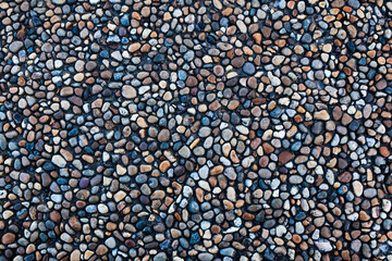 Stones of different shapes, sizes and colors on the seashore, close-up. Background of sea stones.