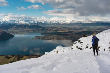 Woman walking in Roy's Peak summit track in winter. Wanaka, Otago, New Zealand