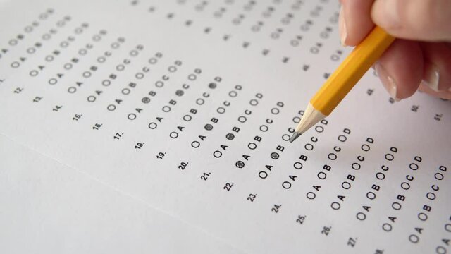 Student taking exams, filling out standardized test form with answers, answer to the questions, education, examination concept.
