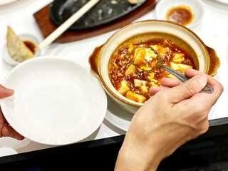 麻婆豆腐を小皿に取り分ける手元