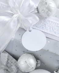 Christmas present with blank gift tag and white decorations, Mockup