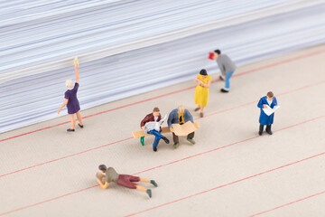 People reading next to miniature creative documents