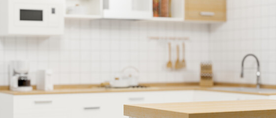 Wooden kitchen counter top on blurry modern white minimalist kitchen room interior