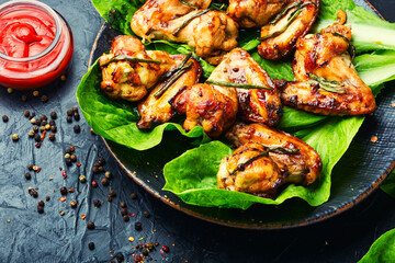 Grilled chicken wings on lettuce leaves