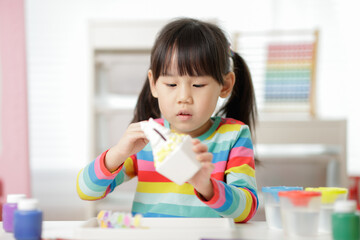 young girl painting money bank craft for homeschooling